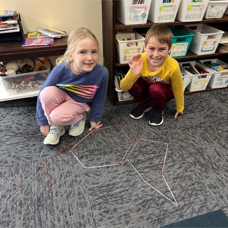 Second graders are making polygons with straws and twist ties.