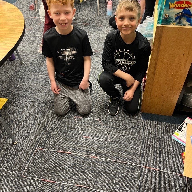 Second graders are making polygons with straws and twist ties.